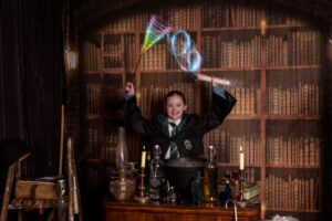 A child in wizard robes casting spells at immersive Wizard School photography experience in East Grinstead