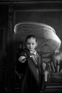 A child in wizard robes casting spells at immersive Wizard School photography experience in East Grinstead