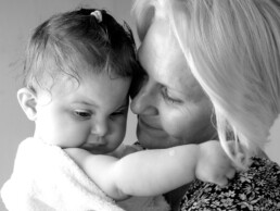 A grandparent sharing a calm, affectionate moment with a one-year-old during a first birthday celebration.