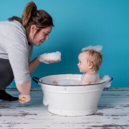 Baby in splash tub with bubbles in studio after cake smash, first birthday photos