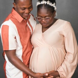 couple connected and looking at the bump of their unborn child