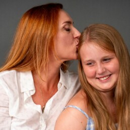 mother kissing her daughter on the head and is so proud