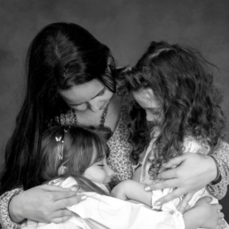 mother protecting her two daughers with love
