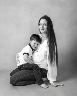 sibling with his unborn brothet cradled in his mohters arms