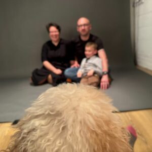 cockerpoo sitting with the photographer taking the photographs