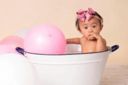 baby girl enjoying her splash bath at her cake smash