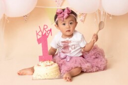 baby girl with her smash cake at her first birthday cake smash